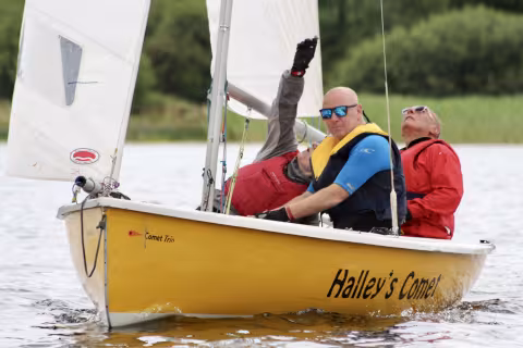 "Look at the burgee!" our instructor guides the trainee helm to set his sails according to the wind-direction shown by the little flag on the mast-tip Adult trainees in a Comet Trio